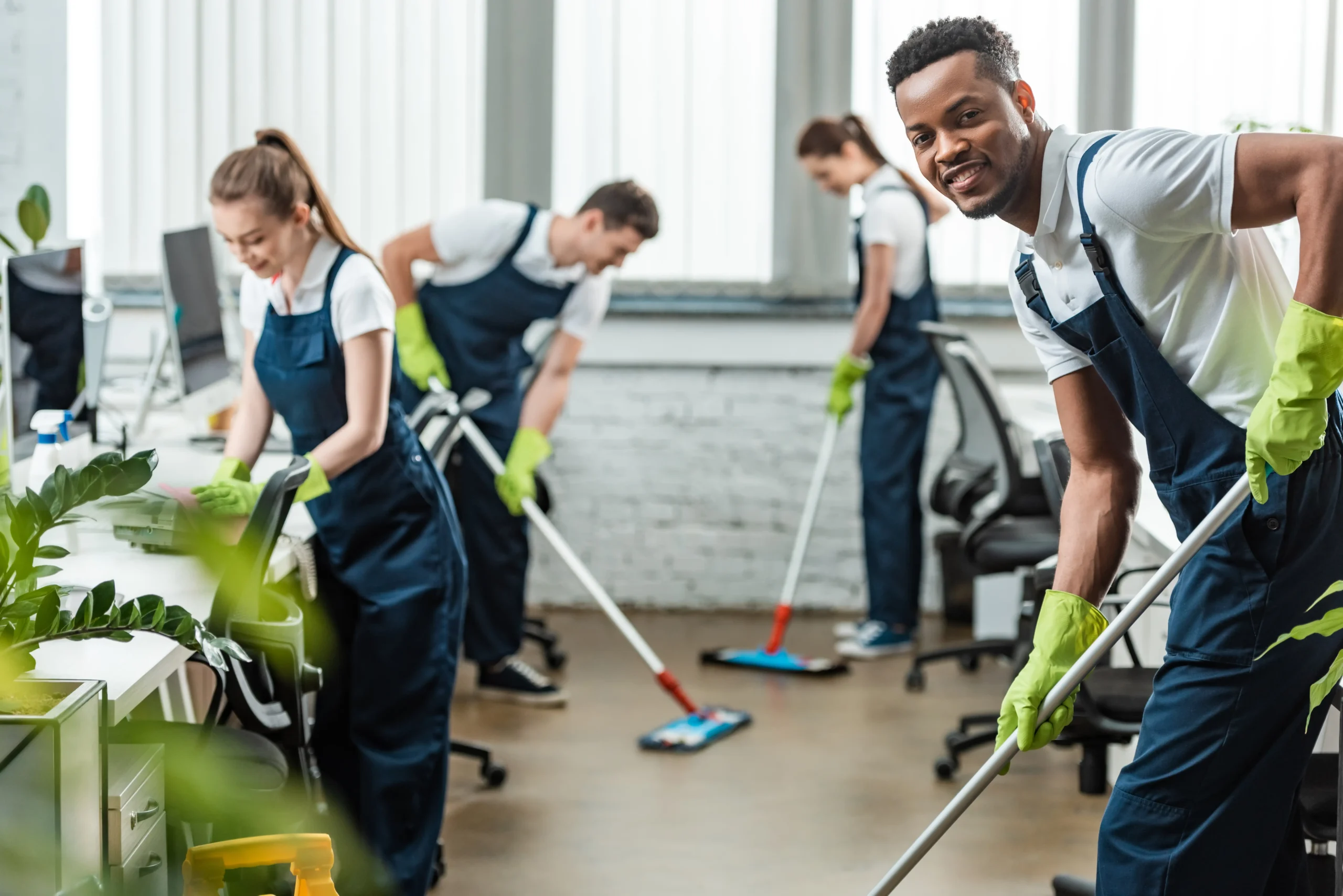 A cleaning crew happily cleaning the company office.