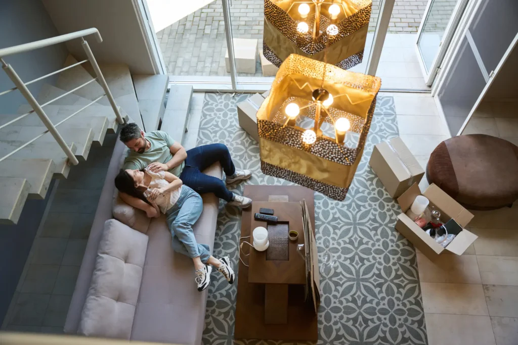 A happy couple resting in the living room of their house.
