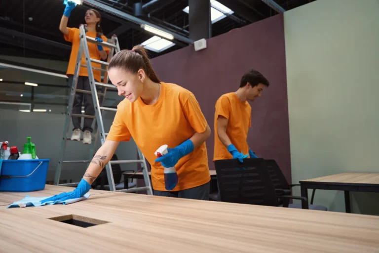 Professional cleaning crew disinfecting office desks and workstations during a commercial cleaning service.